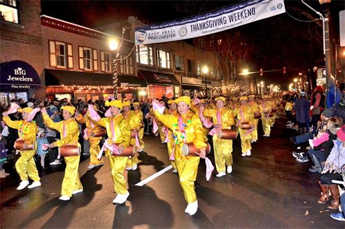 '图1~2:二零一九年十二月六日晚,来自纽约的法轮功腰鼓队在美国费城西郊的西切斯特市参加一年一度的传统圣诞大游行,受到热烈欢迎。这是法轮功连续第12年受邀参加,也是每年游行队伍中唯一的华人团体。'