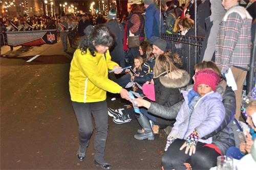 '图3:在游行时,民众和警察欣然接受法轮功学员的真相资料。'