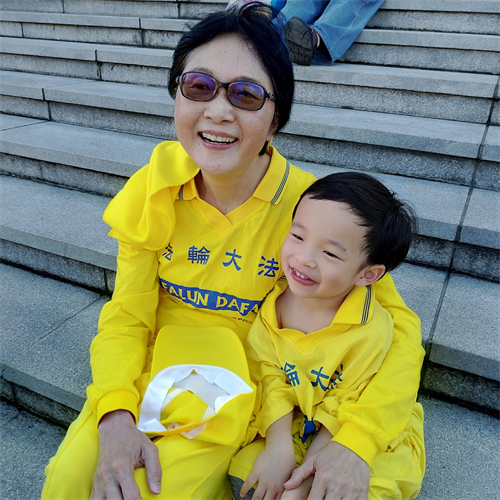 '图:张瑞兰和小孙子一起参加法轮功学员的排字活动。'