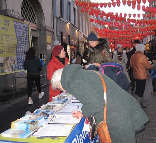 '图11:二零一九年二月十日,来自位于西班牙和法国之间的巴斯克自治区(Basque Country autonomous community)的埃斯特尔(Estelle)女士(左一)在伦敦唐人街签名支持法轮功反迫害'