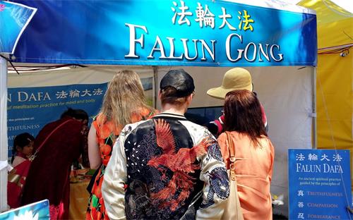 '图3:人们前来展位了解法轮功。'
