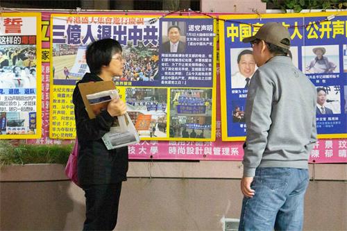 '图3:真相景点的退党义工(左)在和民众讲真相'