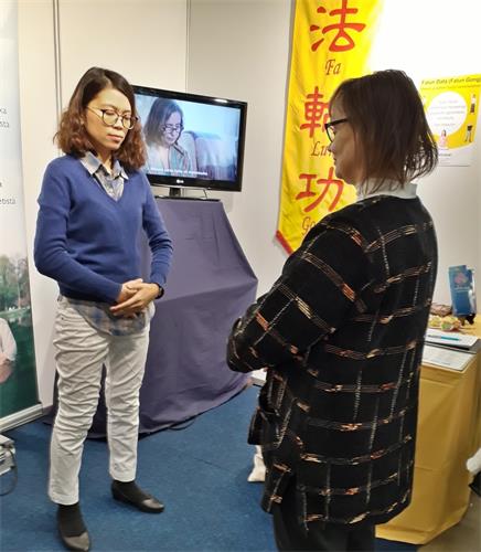 这位女士(左)听了介绍后,当场学炼功法。