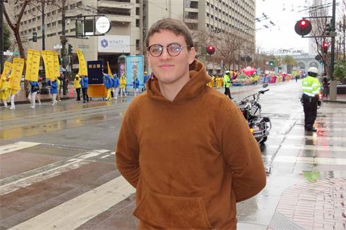 '图27:来自法国的小伙子Amaury很高兴看到法轮功学员的队伍'