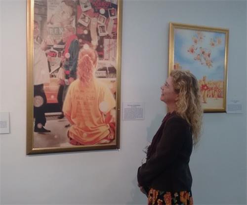 '图4:Evelin在她工作处看到法轮大法的画展很激动'