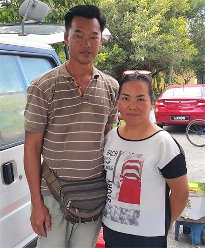 图9:俞美兰女士和她的先生观看了法轮功学员的游行。俞女士祝愿法轮功真相拨云见日。
