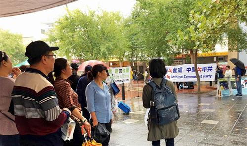 '图3:法轮功学员的讲真相活动,吸引了不少华人驻足了解观看,了解真相。'