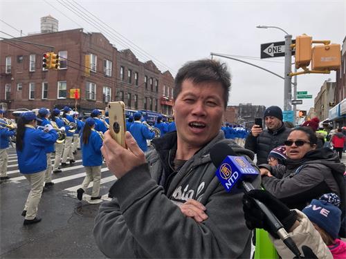 '图12:正在用手机录像的陈先生赞叹天国乐团很棒。'