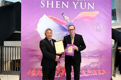 '图10:三月二日下午,神韵在奥克兰首场演出之前,新西兰行动党人权发言人史蒂芬·拜瑞(Stephen Barry)面呈行动党主席、国会议员大卫·西摩(David Seymour)给神韵的贺信。'