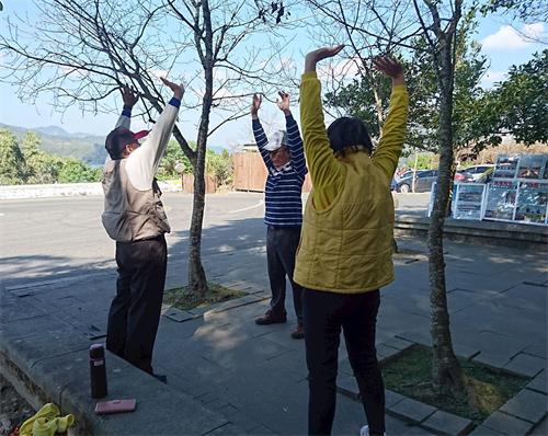 '图5:民众林先生(左一)跟法轮功学员学炼功法。'