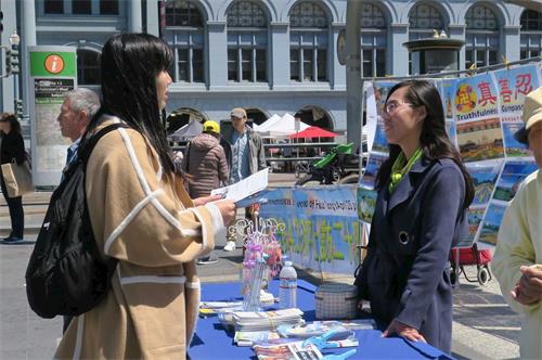 '图7:路人(左)在了解法轮功真相'