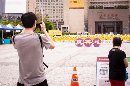 '图9~17:大陆游客为法轮功学员集会场景所吸引,不少人拍照摄影。'