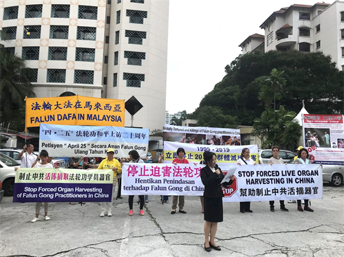 '图1:纪念“四·二五”和平上访二十周年,部份马来西亚法轮功学员在中共驻马大使馆前举行集会,吸引许多官员前来了解法轮功“四·二五”和平上访 真相。'