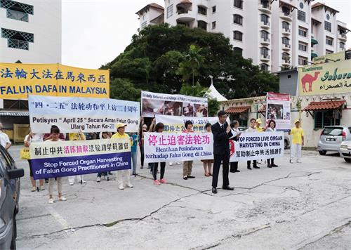 '图2:法轮功学员代表林先生现场宣读马来文文告。'