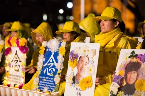 '图3:青年组协调人李菲菲(右一)捧着孙毅的遗照在现场悼念。'