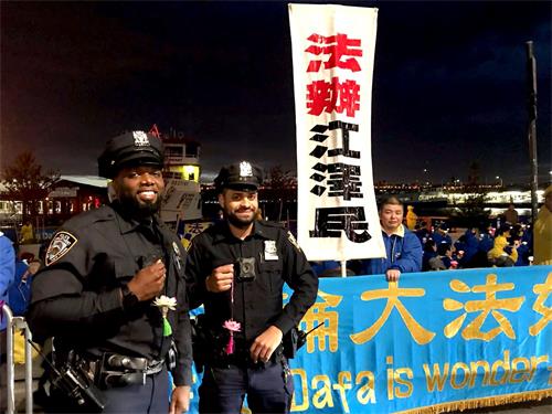 '图14:执勤警察接过法轮功学员赠送的“法轮大法好”的小莲花,表示他们都知道法轮大法好,都知道共产党迫害法轮功。'