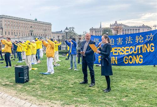 '图1:两位西人学员用瑞典语、英语向当地民众及来自世界各地的游客介绍什么是法轮功以及二十年前的四·二五,发生在北京的和平理性万人上访的事实真相。'