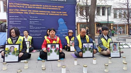 '图2:四月二十四日下午,学员来到首都赫尔辛基市中心举办烛光守夜活动,传播法轮功真相。'