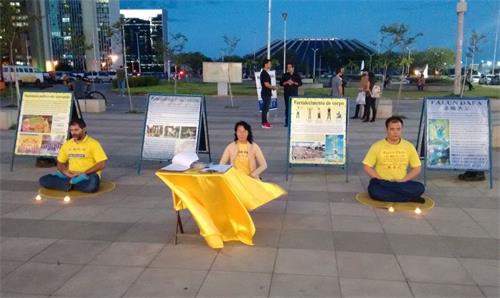 '图6:法轮功学员在巴西利亚市中心举办烛光悼念活动。'