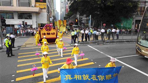 '图12:真相莲花队走过闹市,告诉民众真相就在眼前。'