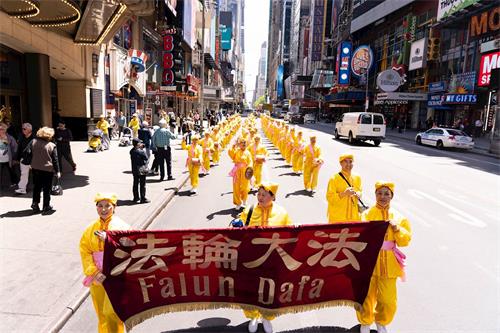 '图11~25:二零一九年五月十六日,万名不同族裔的法轮功学员在纽约曼哈顿中城42街上游行庆祝法轮大法弘传二十七周年,告诉世人“法轮大法好”。'