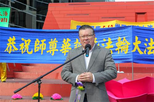 '图1:二零一九年五月十一日,在墨尔本市中心女王桥广场(Queensbridge Square)举行的庆祝法轮大法洪传世界二十七周年庆典上,维州自由党上议院资深议员、反对党党鞭伯尼·菲恩(Bernie Finn MP)先生发言敬贺。'