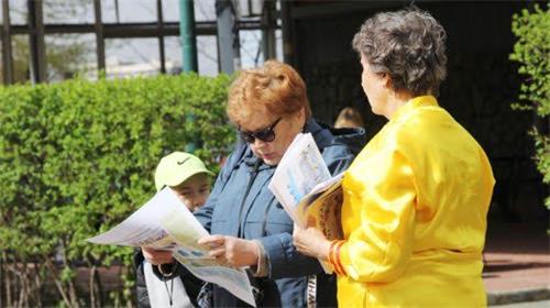 '图16:西伯利亚地区的伊尔库茨克民众接过法轮功真相报纸阅读'