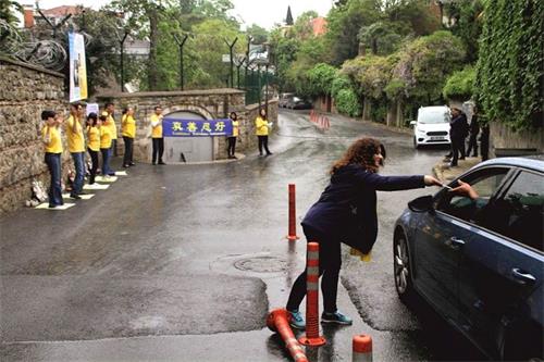 '图2:法轮功学员向经过领事馆的车辆发放真相传单'
