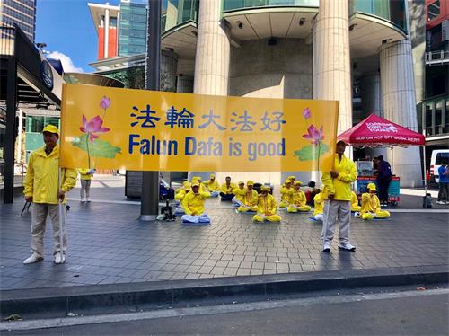'图3:法轮功学员在奥克兰市中心天空城炼功,讲真相'
