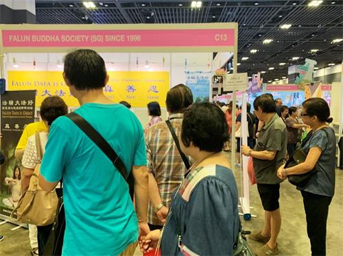 '图2:法轮功的展位吸引了很多人驻足观看。'