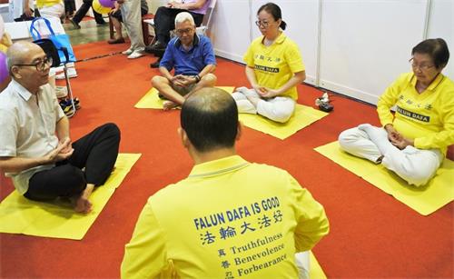 '图4:法轮功学员现场教不同族裔的人士炼静功。'