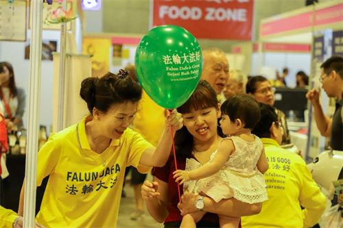 '图5:法轮功学员免费赠送真相气球给小朋友。'