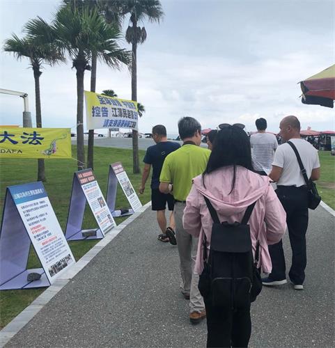 '图4:法轮功学员设置真相看板、横幅,不少路人一边走,一边阅读、了解真相。'