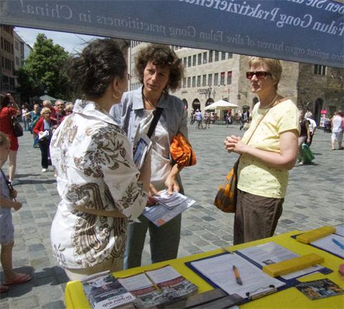 图1~2:二零一九年六月十五日,法轮功学员在纽伦堡(Nürnberg)市中心圣·劳伦斯教堂(St. Lorenz)前举办活动,揭露中共迫害。