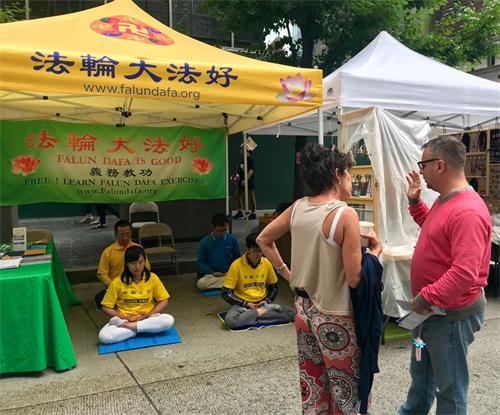 '图1~3:法轮功学员参加纽约曼哈顿第六大道上举办的春天街市,向民众介绍功法。'