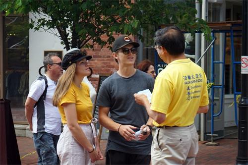'图4:法轮功学员在伯灵顿市繁华市区向民众揭露中共迫害'