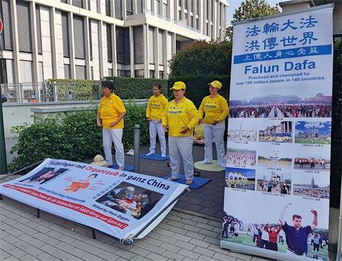 '图1:法轮功学员在中领馆对面演示功法'