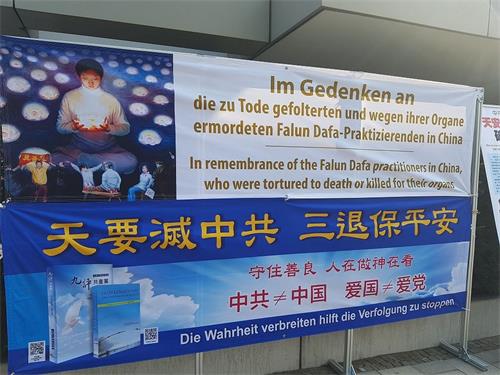 '图2:法轮功学员在中领馆对面展开大型横幅,呼吁中国人三退保平安。'