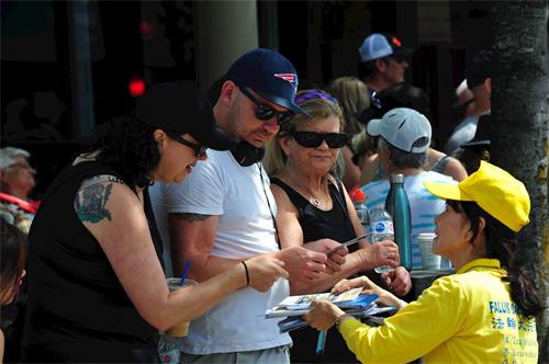 '图6~7:法轮功学员在游行沿途派发真相资料'