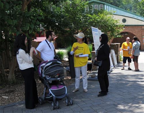 图4: 2019年6月30日,在乔治亚州亚特兰大市石头山脚下的,法轮功真相展板吸引了许多过路人的关注。