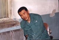 '中新网2002年4月1日的图片显示:关押的房间内血迹斑斑,刘成军显然已无力保持自然坐'