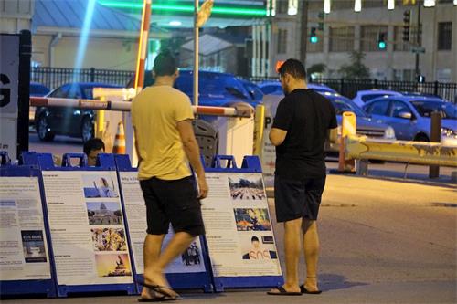 '图7:过往民众驻足观看真相展板'