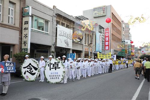 '图7:学员衣着净白素服,手捧被迫害致死的大陆法轮功学员照片,圣洁静肃行进。'
