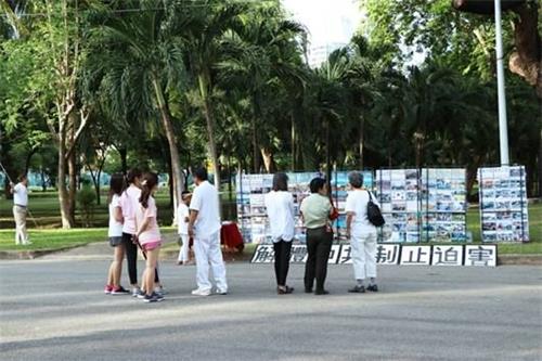 '图3:民众驻足了解法轮功真相'