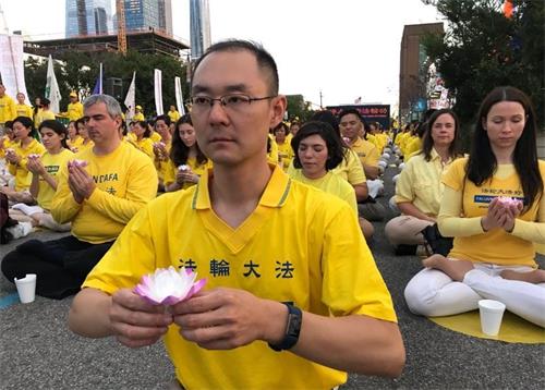 '图8:夜幕低垂,张祎与法轮功学员们,捧起点点烛光,悼念那些只为坚持信仰而被迫害致死的修炼者。'