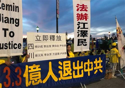 '图9:来自四川的法轮功学员常小春打出展板,要求立即释放四川省绵竹市多名法轮功学员,法办迫害元凶江泽民。'