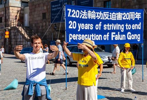 '图6:有的当场就要亲自体验炼功动作,对学炼法轮功表示出极大的兴趣。'