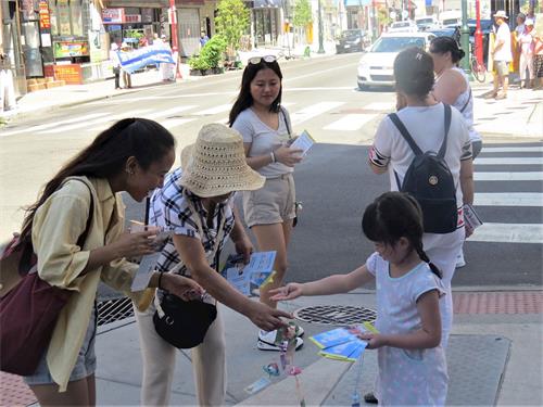 '图6:一位年轻女士高兴地接过象征平安与幸福的小莲花。'
