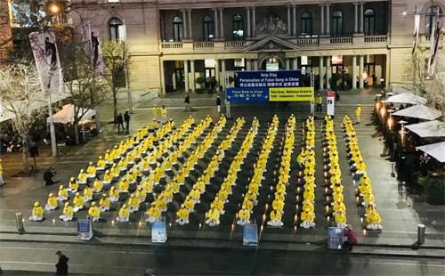 '图1~2:悉尼法轮功学员在海关大楼前烛光悼念二十年中被中共迫害致死的法轮功学员'