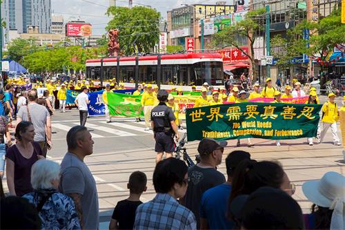 '图3:2019年7月20日,加拿大东部法轮功学员汇集多伦多市中心,举行盛大游行,纪念反迫害20周,呼吁中共停止对法轮功修团体的迫害。'